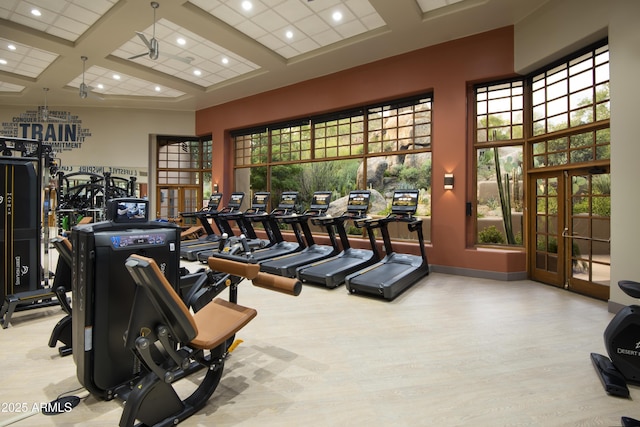 exercise room with a wealth of natural light, french doors, wood finished floors, and coffered ceiling