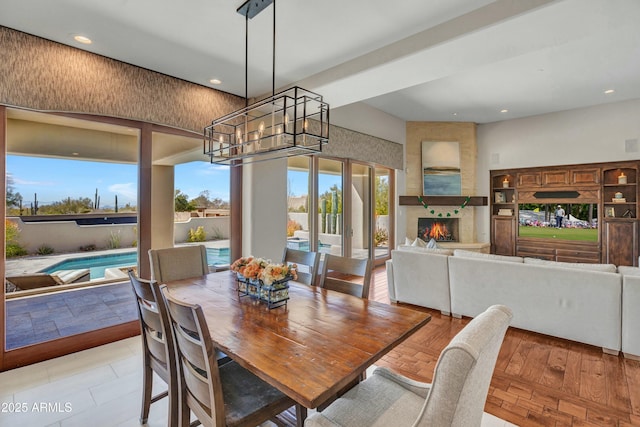 dining space featuring recessed lighting, an inviting chandelier, and a fireplace