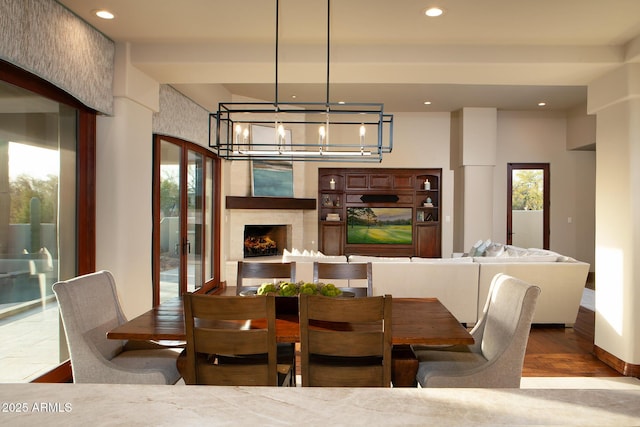 dining area featuring a chandelier, recessed lighting, a fireplace, and wood finished floors