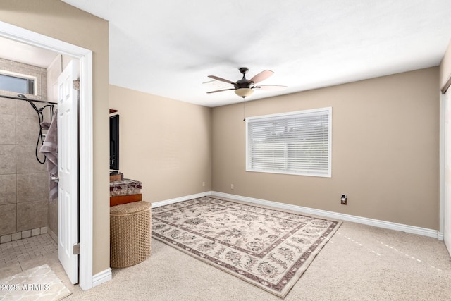 carpeted empty room featuring ceiling fan and baseboards