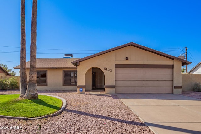 ranch-style home featuring a garage, driveway, roof with shingles, and stucco siding