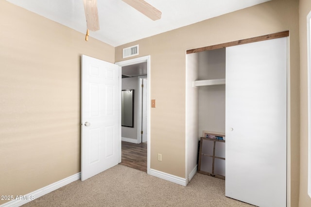 unfurnished bedroom with carpet floors, a closet, visible vents, ceiling fan, and baseboards