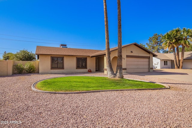 single story home featuring driveway, an attached garage, fence, a front lawn, and stucco siding