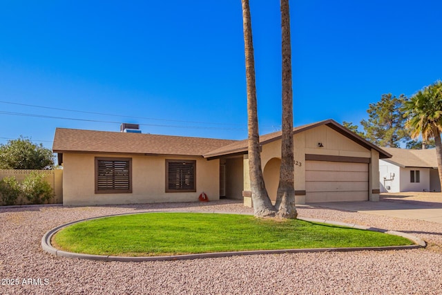 ranch-style home featuring driveway, stucco siding, an attached garage, fence, and a front yard