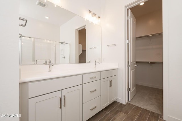 352 E Las Perlas Ln, San Tan Valley, AZ 85140 - full bathroom featuring a shower stall, double vanity, wood finished floors, a spacious closet, and recessed lighting