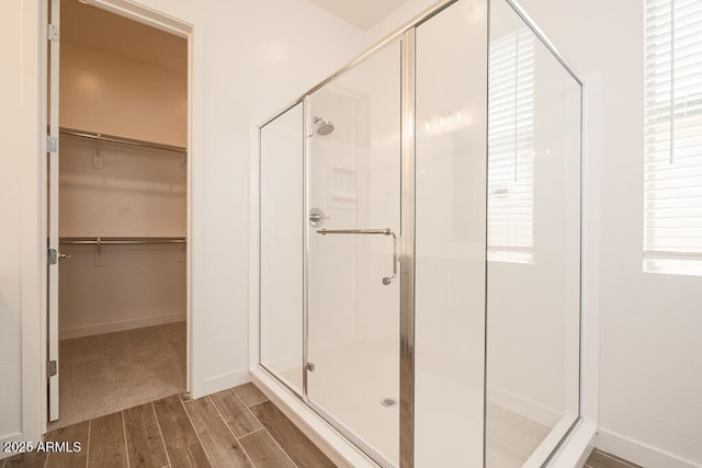 352 E Las Perlas Ln, San Tan Valley, AZ 85140 - bathroom with a shower stall, wood finished floors, a spacious closet, and baseboards