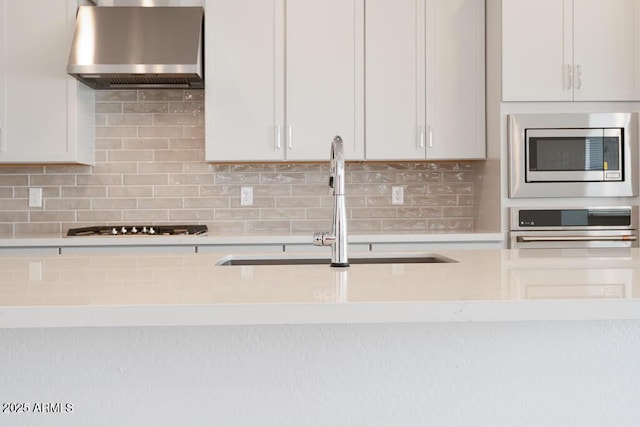 352 E Las Perlas Ln, San Tan Valley, AZ 85140 - kitchen with wall chimney range hood, stainless steel appliances, light countertops, and a sink