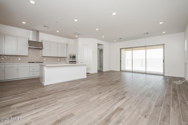 352 E Las Perlas Ln, San Tan Valley, AZ 85140 - kitchen featuring open floor plan, stovetop, wall chimney range hood, oven, and light countertops