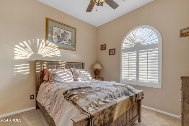 carpeted bedroom with multiple windows, ceiling fan, and vaulted ceiling