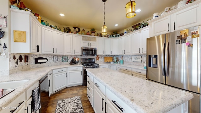 kitchen with white cabinets, backsplash, decorative light fixtures, and appliances with stainless steel finishes