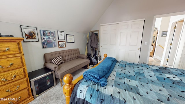 bedroom with a closet, light carpet, and vaulted ceiling