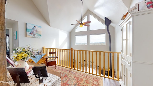 living area with high vaulted ceiling, light hardwood / wood-style floors, and ceiling fan