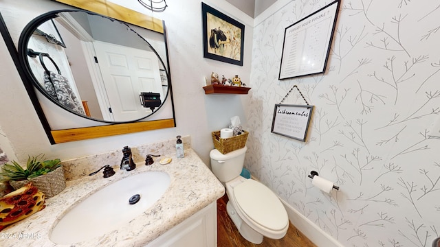 bathroom with hardwood / wood-style flooring, vanity, and toilet