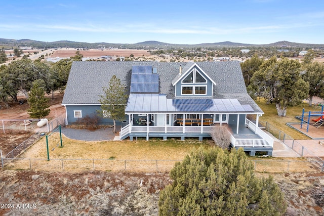 view of front facade with a deck with mountain view and solar panels