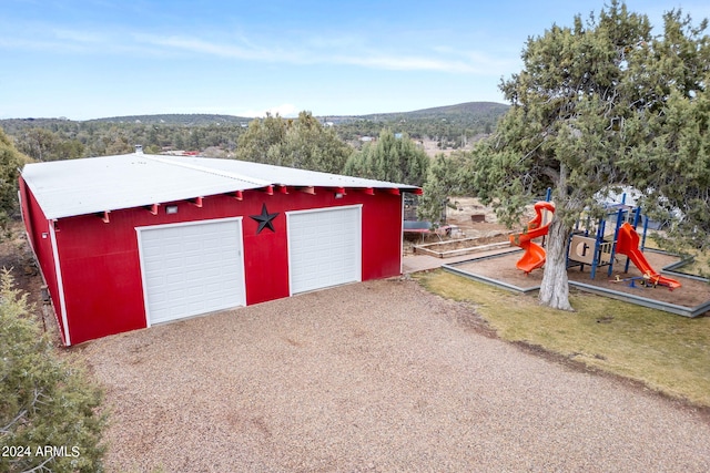 exterior space with a playground and a garage