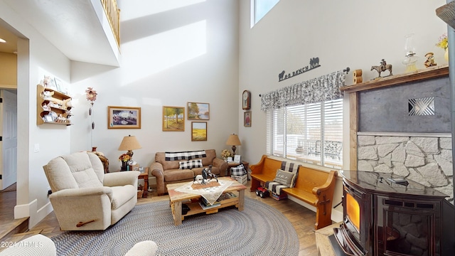 living room featuring a high ceiling, hardwood / wood-style flooring, and a fireplace