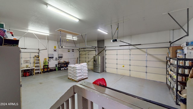 garage featuring stainless steel fridge and a garage door opener