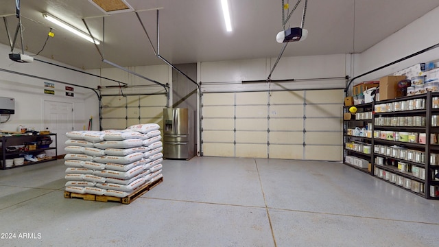 garage with stainless steel fridge and a garage door opener