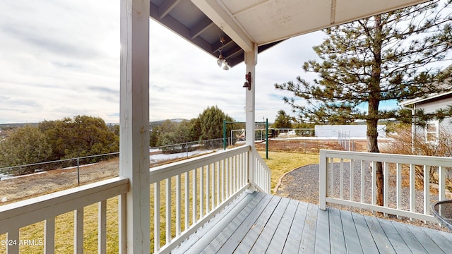 wooden deck featuring a lawn