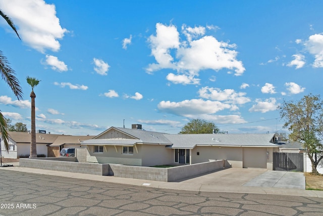 view of front of house featuring a fenced front yard, a gate, and stucco siding