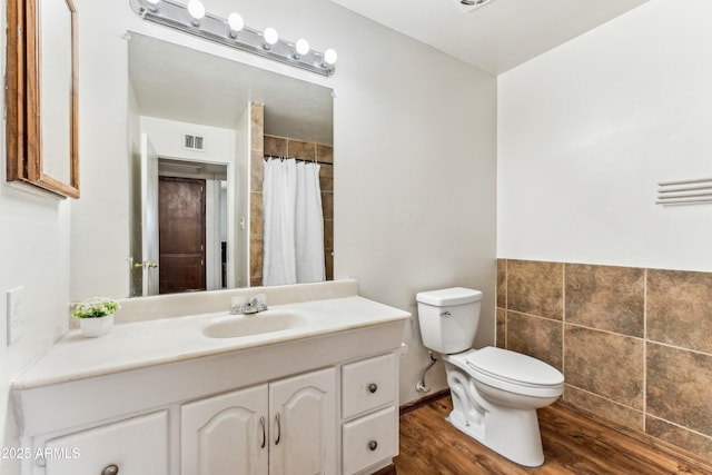 bathroom featuring toilet, wood finished floors, vanity, visible vents, and a shower with curtain