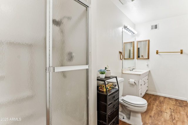 bathroom featuring a stall shower, visible vents, toilet, wood finished floors, and vanity