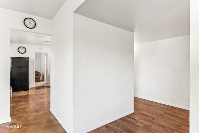 corridor featuring wood finished floors and baseboards