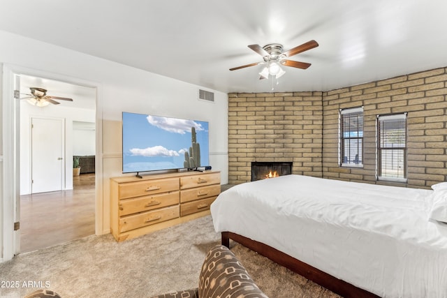 bedroom featuring ceiling fan, a fireplace, and visible vents