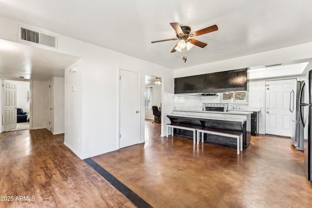 interior space featuring ceiling fan, concrete floors, visible vents, and baseboards