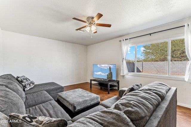 living room featuring a ceiling fan, baseboards, and wood finished floors