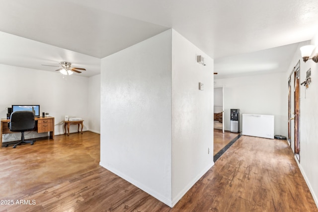 corridor featuring wood finished floors and baseboards