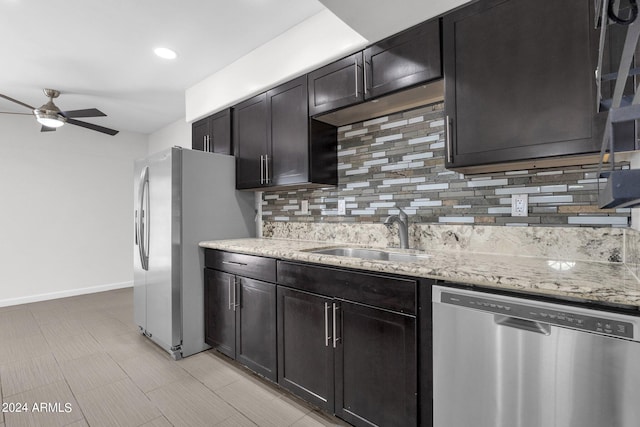 kitchen featuring stainless steel appliances, backsplash, ceiling fan, and sink