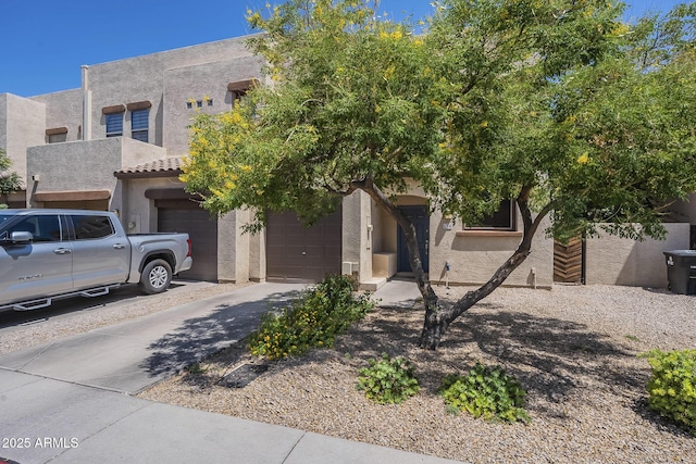 1886 E Don Carlos Ave Unit 136, Tempe, AZ 85281 - view of front of house with stucco siding, a garage, and driveway