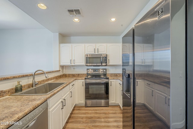 1886 E Don Carlos Ave Unit 136, Tempe, AZ 85281 - kitchen with appliances with stainless steel finishes, light wood-type flooring, white cabinets, and recessed lighting