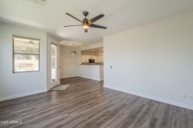 1886 E Don Carlos Ave Unit 136, Tempe, AZ 85281 - unfurnished living room featuring dark wood-type flooring and ceiling fan