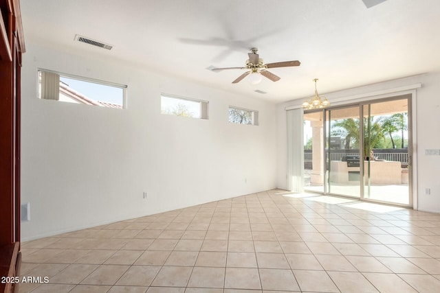 tiled empty room with ceiling fan with notable chandelier