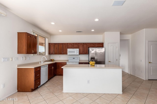 kitchen featuring sink, stainless steel appliances, a center island, and light tile patterned flooring