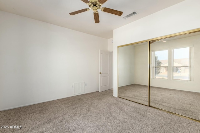 unfurnished bedroom featuring carpet floors, ceiling fan, and a closet