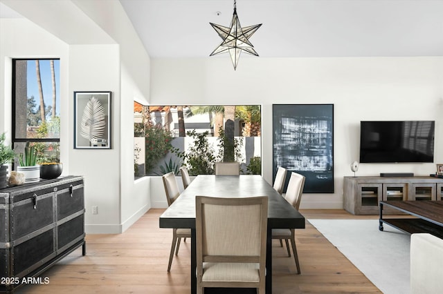 dining area with an inviting chandelier, light wood-style flooring, and baseboards