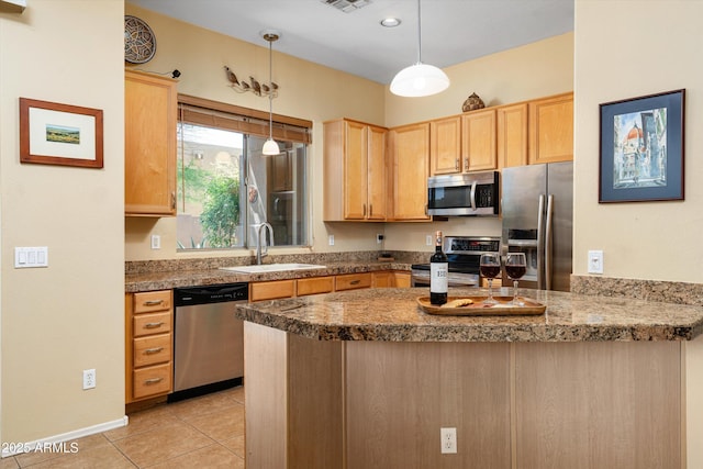 kitchen with light brown cabinets, a peninsula, appliances with stainless steel finishes, and a sink