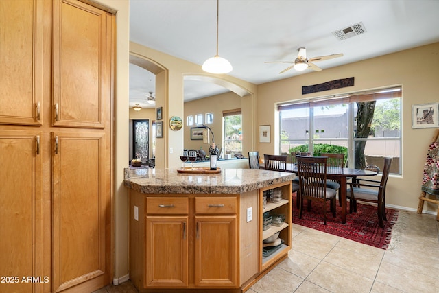 kitchen with visible vents, light tile patterned floors, a ceiling fan, and a peninsula