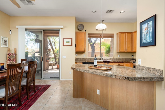 kitchen with visible vents, a peninsula, and a healthy amount of sunlight