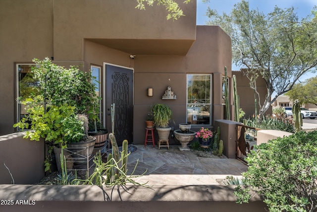 property entrance featuring stucco siding and a patio area