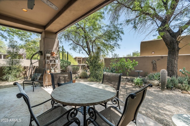 view of patio with outdoor dining space, ceiling fan, and a fenced backyard