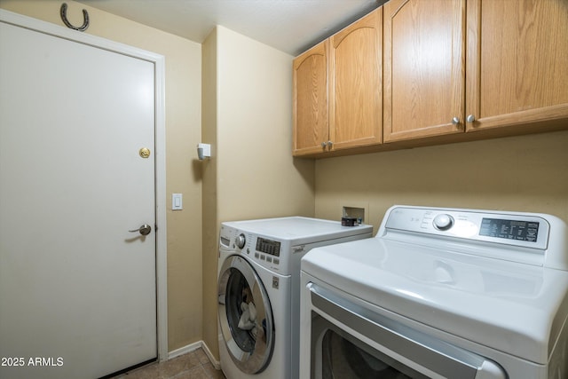 clothes washing area with baseboards, washer and dryer, cabinet space, and tile patterned flooring