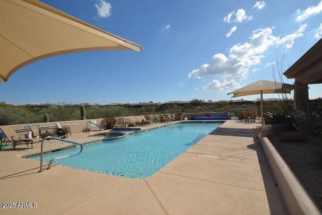 community pool featuring a patio and an in ground hot tub