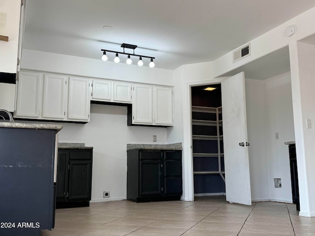 kitchen with light tile patterned flooring and white cabinets