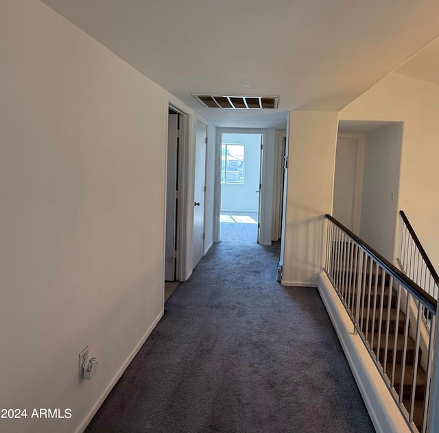 hallway featuring dark colored carpet