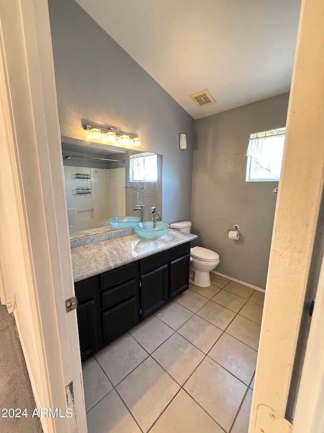 bathroom featuring lofted ceiling, vanity, toilet, and tile patterned flooring