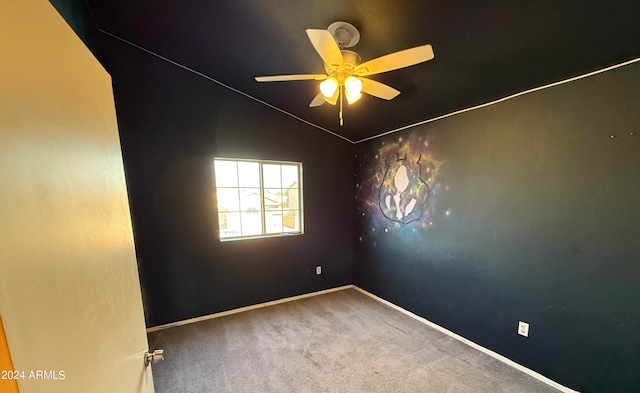 carpeted spare room featuring ceiling fan and lofted ceiling